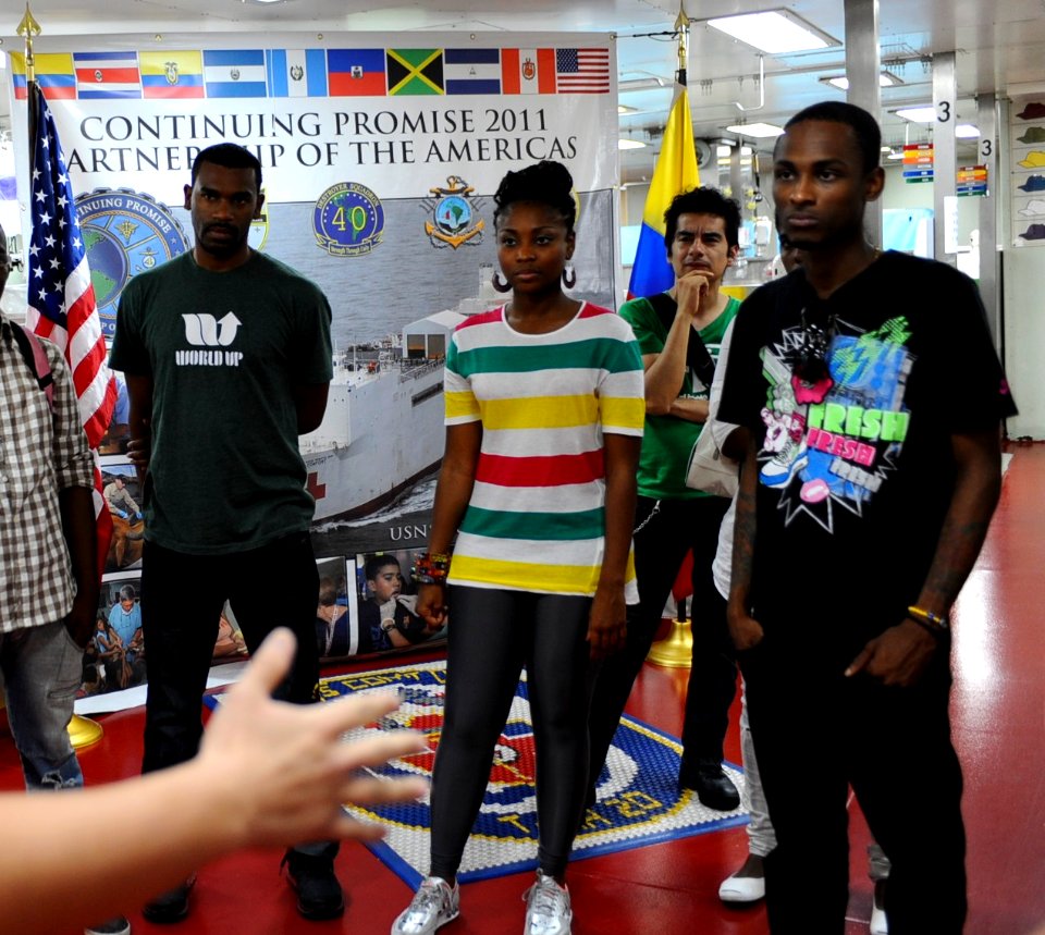 US Navy 110609-F-CF975-040 Hospital Corpsman 3rd Class Brent Snyder welcomes hip-hop band Chocquib Town to USNS Comfort (T-AH 20)