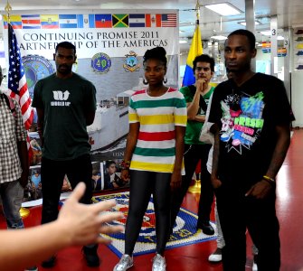 US Navy 110609-F-CF975-040 Hospital Corpsman 3rd Class Brent Snyder welcomes hip-hop band Chocquib Town to USNS Comfort (T-AH 20)
