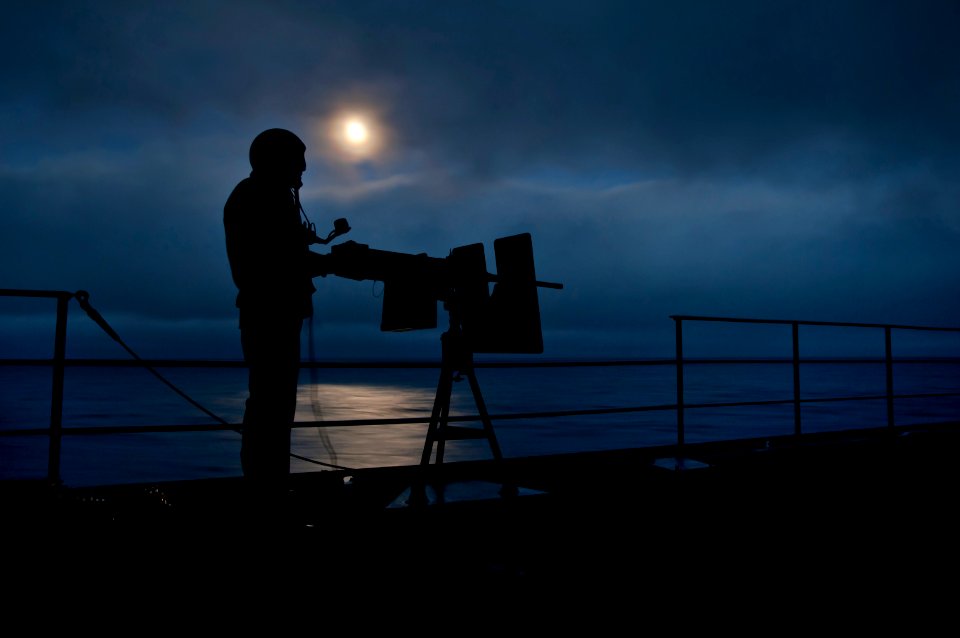 US Navy 110613-N-DR144-603 Aviation Ordnanceman 2nd Class Jacob Lopez waits to fire a .50 caliber machine gun from a sponson aboard USS Carl Vinson