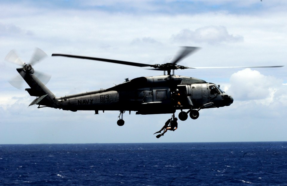 US Navy 110611-N-GZ277-278 An SH-60F Sea Hawk helicopter assigned to Helicopter Anti-submarine Squadron (HS) 15, deploys a rescue swimmer over the