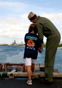 US Navy 110610-N-MD252-041 Lt. Cmdr. Doug Wyman and his sponsored tiger cruise participant view the Battleship Missouri Memorial from the flight de