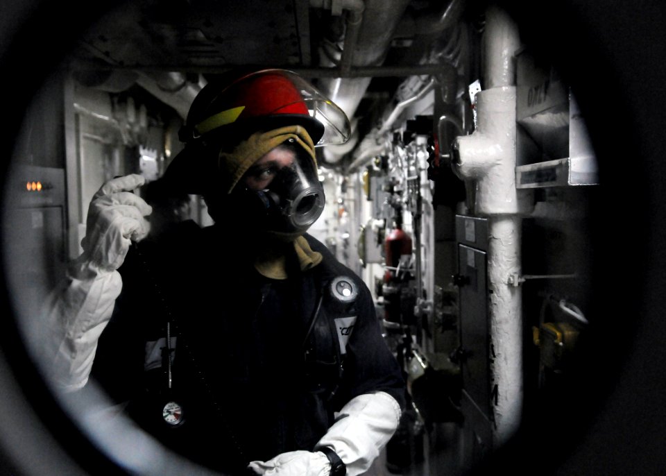 US Navy 110614-N-KB052-029 Engineman 3rd Class Charlie Shroba relays a message from the scene of a simulated class charlie fire to the repair locke