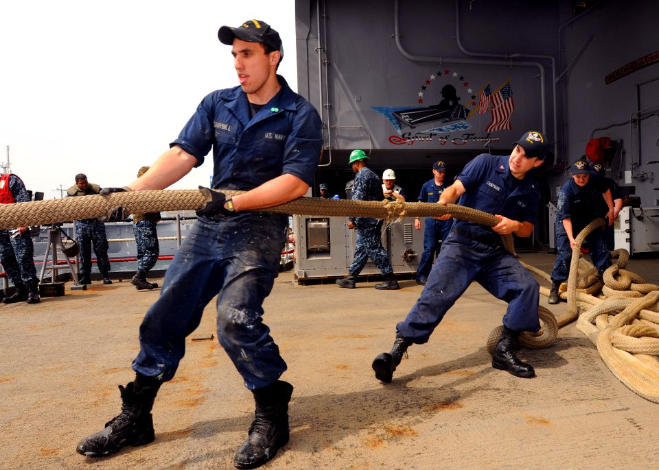 US Navy 110612-N-DS193-079 Seaman Lee Graybill, left, and Logistics Specialist 3rd Class James Chapman heave the number 10 shore line as the crew g