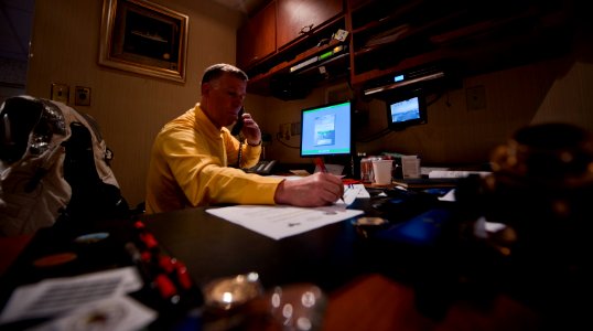 US Navy 110613-N-TU221-027 Capt. Bruce H. Lindsey takes notes during a telephone interview with various news organizations inside his in-port cabin