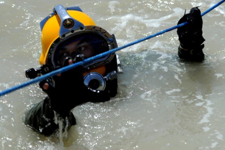 US Navy 110614-N-WL435-477 Staff Sgt. Jake Cochran works his way down a traveling line after working on a sunken pier dive project