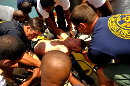 US Navy 110614-N-KB666-481 Members of Mobile Diving and Salvage Unit (MDSU) 2 and multinational divers load Chief Hospital Corpsman Nathanael Warre