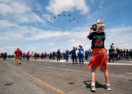 US Navy 110611-N-DR144-594 Sailors, friends and family watch a formation of aircraft assigned to Carrier Air Wing (CVW) 17 from the flight deck of