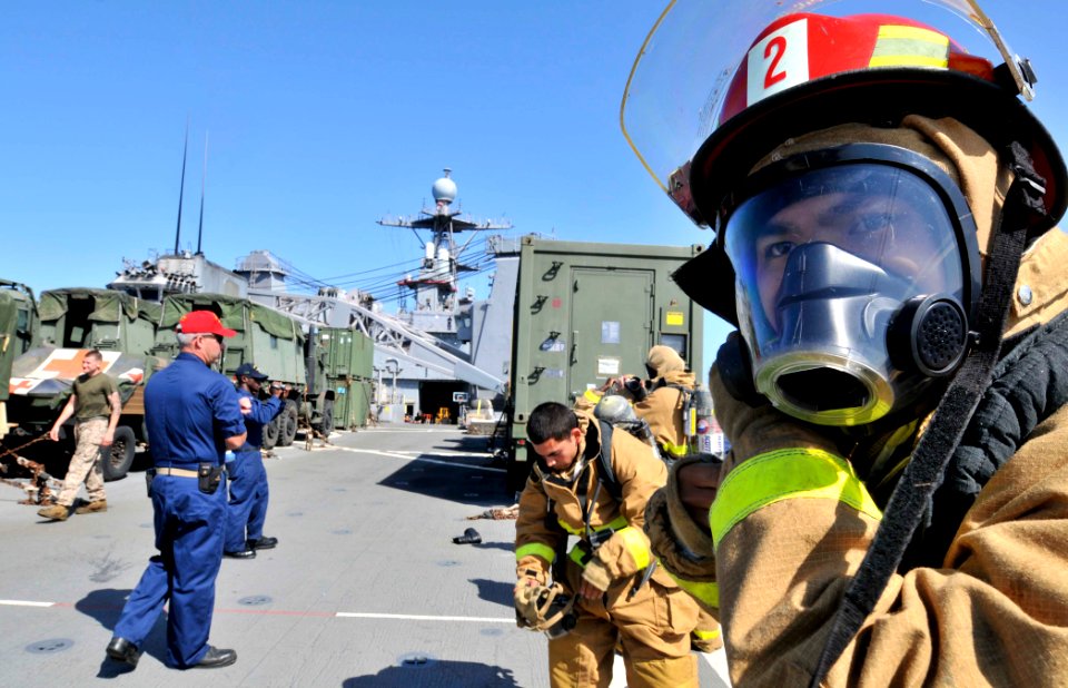 US Navy 110611-N-QP268-426 Boatswain's Mate Seaman Boyu Huang dons a self-contained breathing apparatus during the damage control Olympics aboard U