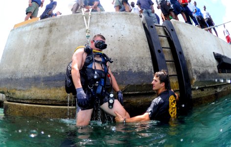US Navy 110614-N-XD935-042 Navy Diver 2nd Class Ryan Arnold guides Chief Hospital Corpsman Nathanael Warren, who is acting as an unconscious diver