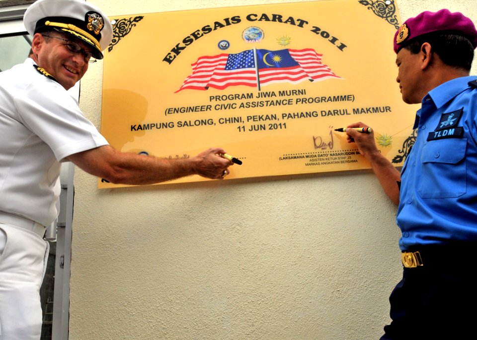 US Navy 110611-N-NJ145-125 Capt. John W. Gilman and Royal Malaysian Navy Rear Adm. Nasaruddin bin Othman ign the dedication plaque during the turno