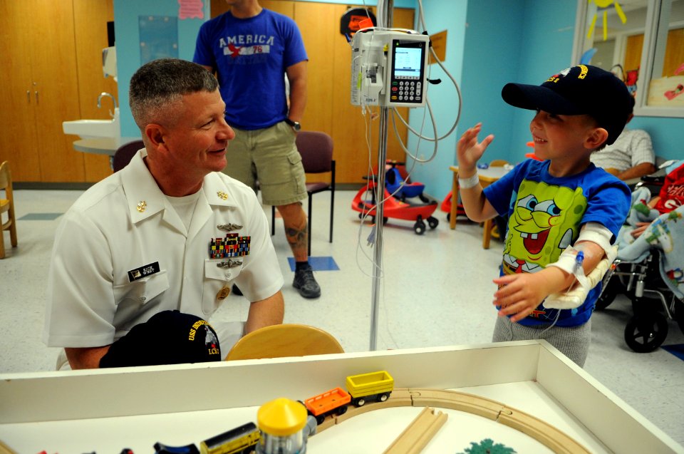 US Navy 110614-N-AD372-024 Master Chief Petty Officer of the Navy (MCPON) Rick D. West makes a child an honorary Sailor during a Caps for Kids even