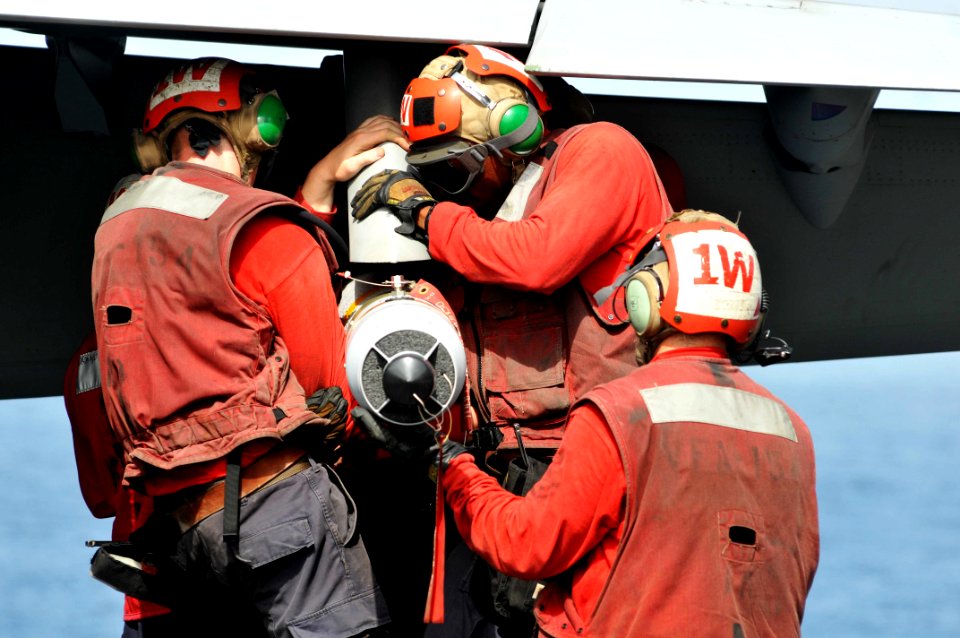 US Navy 110613-N-GL340-186 Aviation ordnancemen install ordnance on an aircraft aboard the aircraft carrier USS Ronald Reagan (CVN 76)