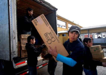 US Navy 110612-N-ZI300-043 Volunteers at a shelter for evacuees of an eruption of Mount Puyehue unload supplies and donations from Project Handclas