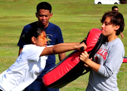 US Navy 110617-N-BK435-126 Machinery Repairman Fireman Recruit Chloe Chhuop slams her baton into Engineman 3rd Class Chrissy Rivera's bag during an