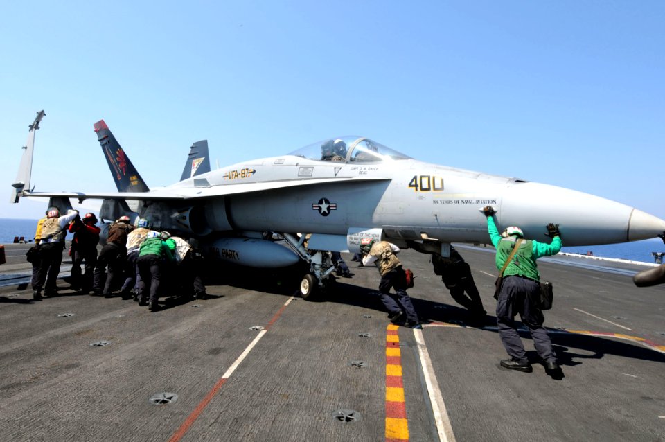 US Navy 110616-N-QL471-299 Sailors maneuver an F-A-18A Hornet aboard the aircraft carrier USS George H.W. Bush (CVN 77)