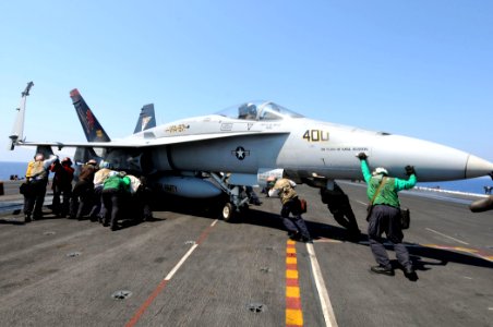 US Navy 110616-N-QL471-299 Sailors maneuver an F-A-18A Hornet aboard the aircraft carrier USS George H.W. Bush (CVN 77)