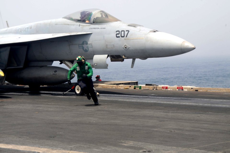 US Navy 110618-N-NB544-072 Aviation Boatswain's Mate (Equipment) Airman Aaron Jones runs for the safety shot line as an F-A-18E Super Hornet prepar