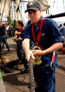 US Navy 110619-N-AU127-480 Aviation Electrician's Mate Airman John Fisher, assigned to USS Constitution, heaves a line during sail training aboard