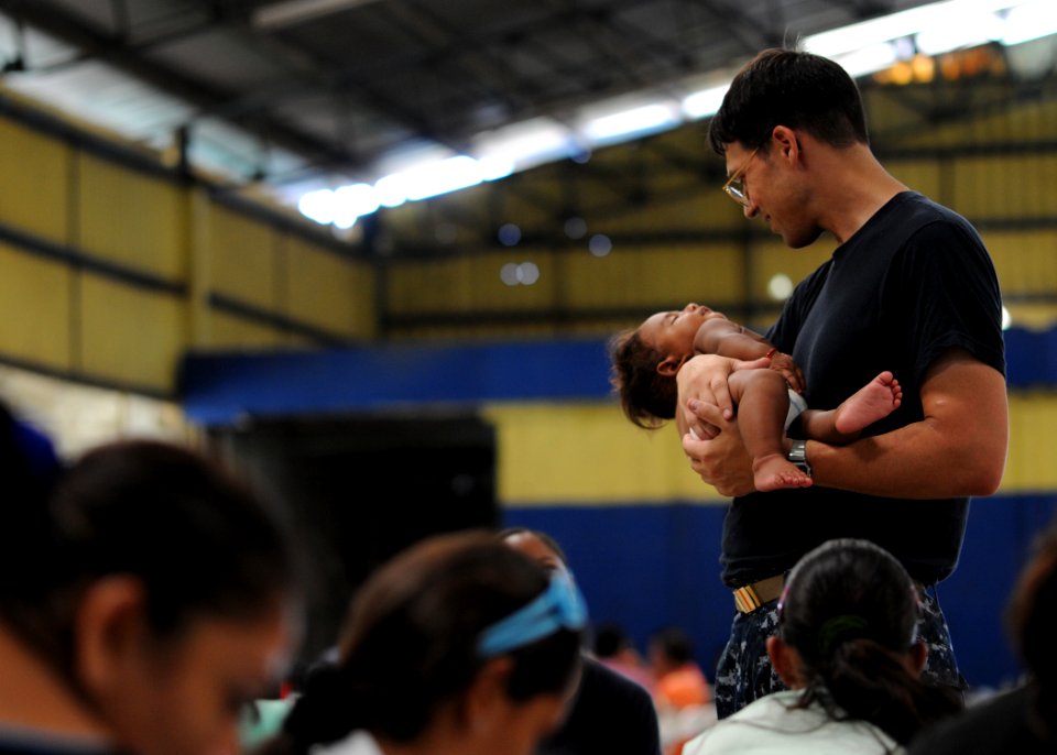 US Navy 110620-N-NY820-358 Lt. Cmdr. Jason Layton, from Wexford, Penn., holds a child in a staging area at the Centro Civico medical site during a