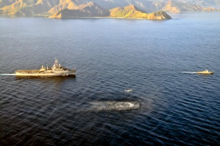 US Navy 110616-O-ZZ999-010 The amphibious transport dock ship USS Cleveland (LPD 7) follows an MH-60S Sea Hawk helicopter and a Timor-Leste patrol