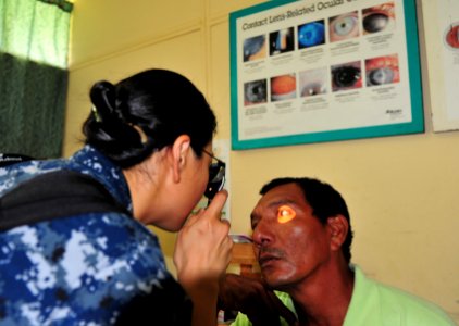 US Navy 110618-F-NJ219-187 Lt. Eva Chou, an ophthalmologist from Hacienda Heights, Calif., examines a patient's eyes during a surgical screening a photo