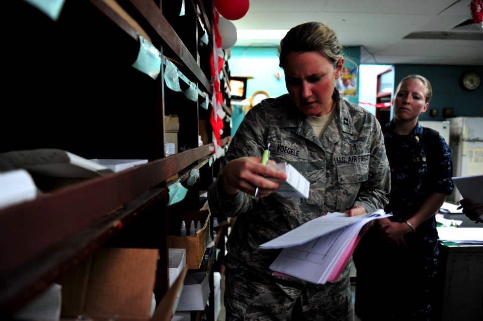 US Navy 110617-F-NJ219-054 Air Force Capt. Laura Voegele, a physician from LaGrange, Ky., verifies the dosage on a prescription label during a subj