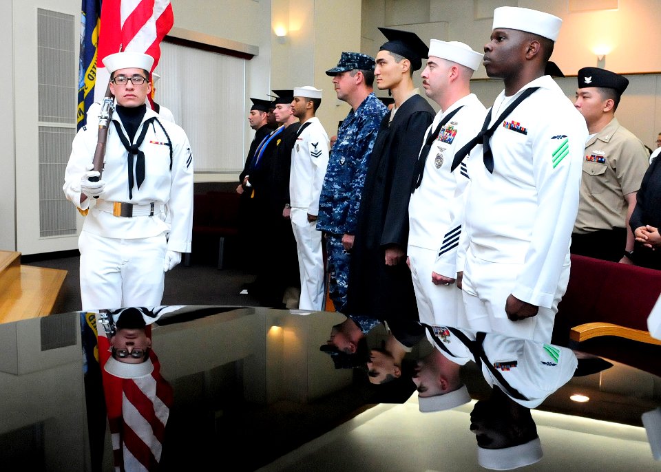 US Navy 110616-N-WJ771-010 A ceremonial color guard parades the colors during a college graduation ceremony at the Community and Education Center a