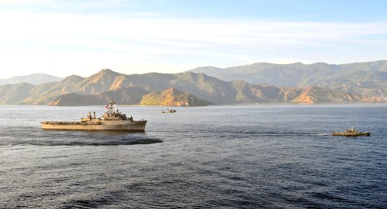US Navy 110616-O-ZZ999-013 The amphibious transport dock ship USS Cleveland (LPD 7) follows an MH-60S Sea Hawk helicopter and a Timor-Leste patrol
