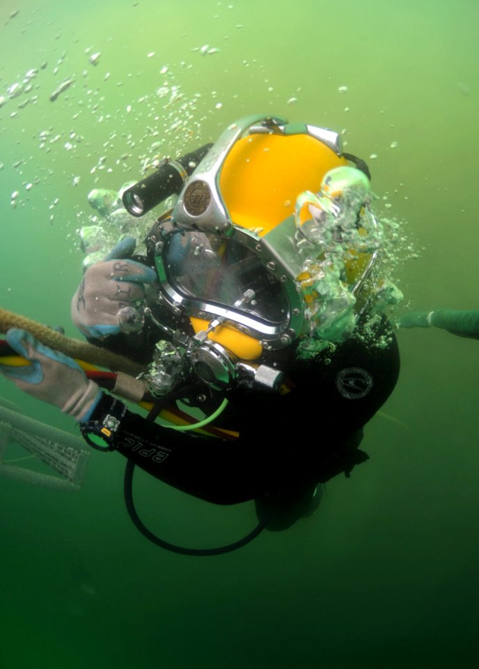 US Navy 110618-N-VF350-065 Hospital Corpsman 2nd Class Jose Lopez, assigned to Mobile Diving and Salvage Unit (MDSU) 1, descends underwater during