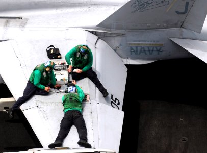 US Navy 110621-N-QL471-079 Sailors assigned to Strike Fighter Squadron (VFA) 15 perform maintenance on an F-A-18C Hornet aboard the aircraft carrie