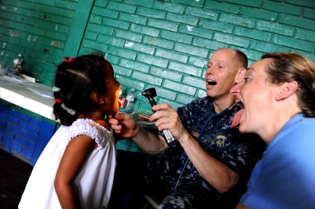 US Navy 110620-F-ET173-236 Medical professionals examine a patient at the Escuela Humberto Mendez Juarez medical site photo