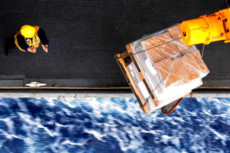 US Navy 110621-N-RC734-194 Boatswain's Mate 2nd Class Charles Shatto directs the placement of supplies aboard USS Comstock (LSD 45) during a connec