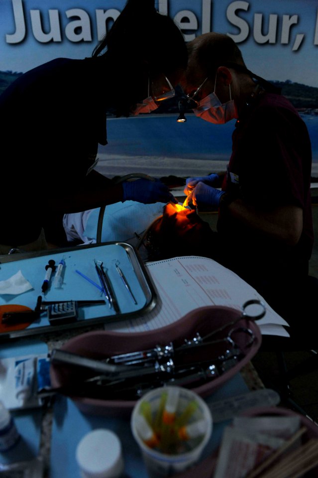 US Navy 110618-F-ET173-105 Capt. Thomas Hudson, from East Alton, Ill., and Jessica Vergel de Dios, from Los Angeles, perform a dental procedure at