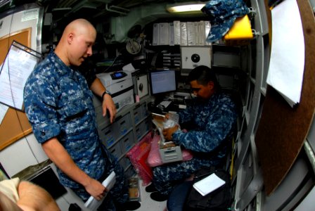 US Navy 110621-N-NK458-166 Machinist's Mate 3rd Class Aaron Haugen checks with Logistics Specialist 3rd Class David Terrones on the availability of