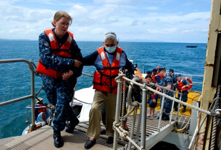US Navy 110623-N-RM525-011 Lt. Cmdr. Francine Worthington helps an elderly Nicaraguan woman cross the gangway aboard USNS Comfort (T-AH 20)