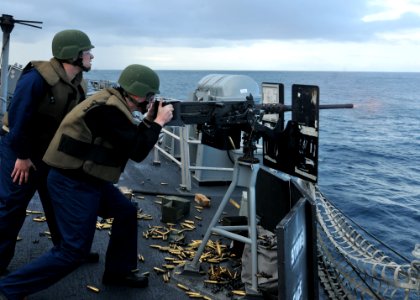 US Navy 110619-N-NL541-329 Midshipmen 2nd Class Alex Nestle fires a .50-caliber machine gun aboard the guided-missile frigate USS Thach (FFG 43)