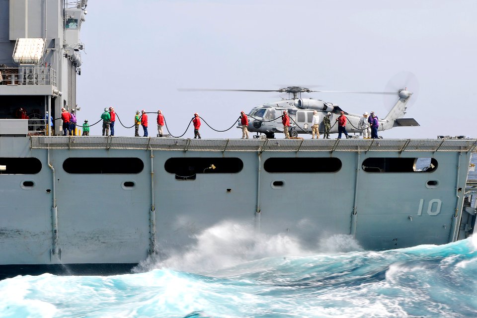 US Navy 110623-N-EE987-649 Sailors recover fueling hoses after fueling an MH-60S Sea Hawk helicopter assigned to the Wild Cards of Helicopter Sea C