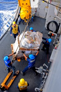 US Navy 110621-N-RC734-098 Sailors assigned to USS Comstock (LSD 45) handle supplies during a connected replenishment with USNS Tippecanoe (T-AO 19