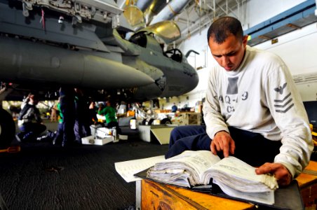 US Navy 110621-N-EE987-065 Aviation Structural Mechanic Equipment 1st Class Christopher Alba eviews procedures for an engine change while Sailors p