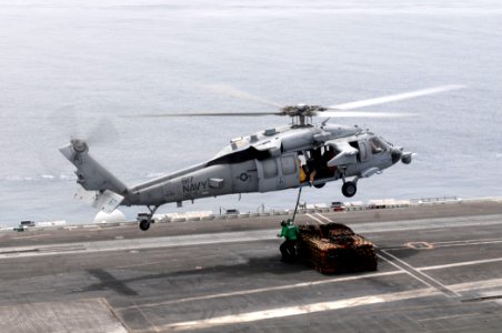 US Navy 110621-N-QL471-117 Sailors hook cargo nets to an MH-60S Sea Hawk helicopter assigned to Helicopter Sea Combat Squadron (HSC) 9 during a ver
