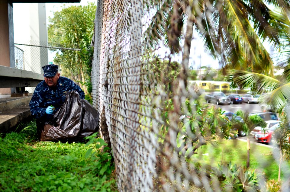US Navy 110622-N-WP746-042 Chief Warrant Officer 3 Carlos Choto icks up rubbish along Kamehameha Highway, outside the Pearl Harbor Visitors Center