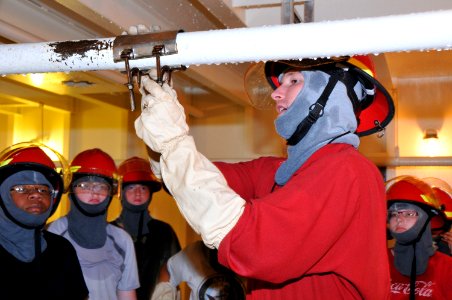 US Navy 110622-N-IK959-736 Damage Controlman 2nd Class George Christie instructs Navy JROTC cadets on pipe patching during the 2011 NJROTC Leadersh photo