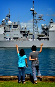 US Navy 110624-N-RI884-066 Family members of Sailors assigned to the Ticonderoga-class guided-missile cruiser USS Port Royal (CG 73) wave as the sh