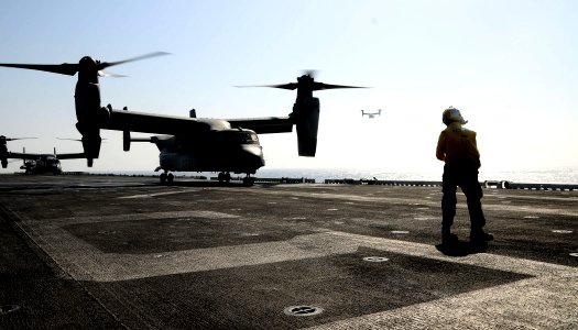 US Navy 110624-N-EC658-003 A Sailor guides an MV-22B Osprey aboard USS Bataan (LHD 5) photo