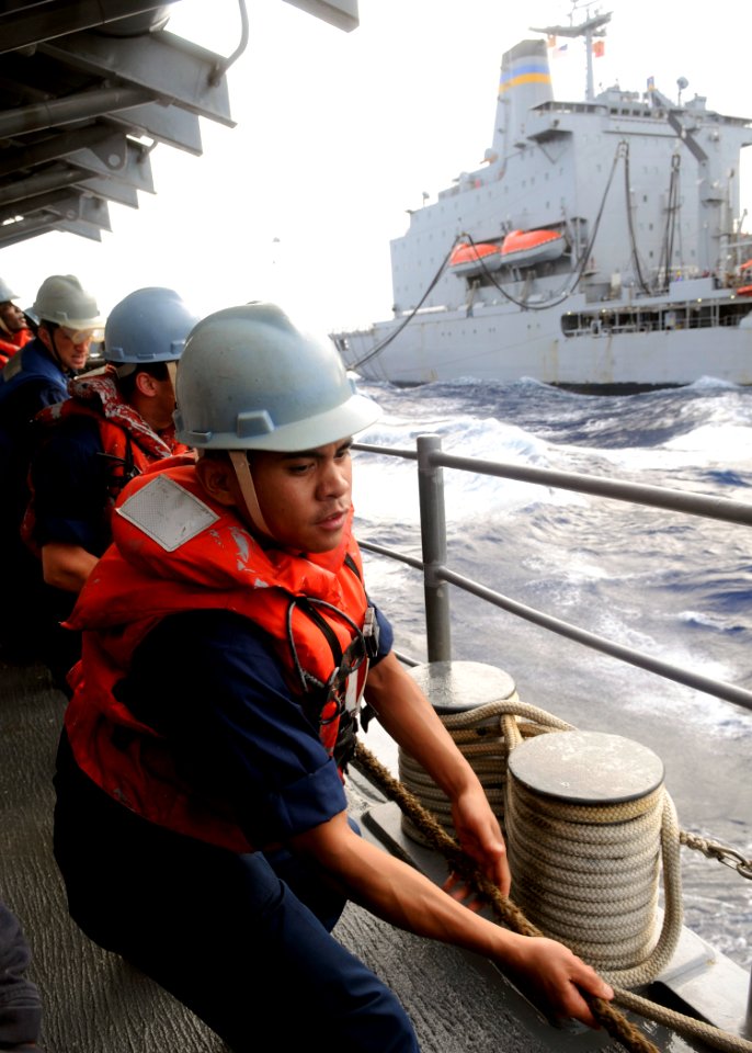 US Navy 110627-N-KB052-379 Sonar Technician (Surface) 2nd Class Christopher Delossantos heaves a line aboard the Ticonderoga-class guided-missile c