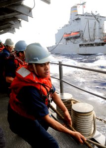 US Navy 110627-N-KB052-379 Sonar Technician (Surface) 2nd Class Christopher Delossantos heaves a line aboard the Ticonderoga-class guided-missile c