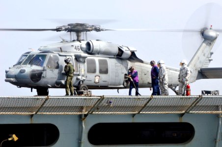 US Navy 110623-N-EE987-623 Sailors refuel an MH-60S Sea Hawk helicopter assigned to the Wild Cards of Helicopter Sea Combat Squadron (HSC) 23