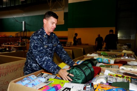 US Navy 110627-N-ZZ999-089 Chief Mineman Dan Ward, from Pflugerville Texas, places a sleeping bag in a box destined for an orphanage in northern Ja