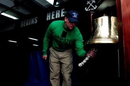 US Navy 110623-N-SB672-006 Ensign Trent Barnes, from San Antonio, rings the bell during a change of command ceremony for the Cougars of Tactical El