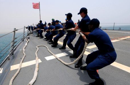US Navy 110626-N-TB177-311 Sailors aboard the guided-missile destroyer USS Truxtun (DDG 103) heave a line as the ship pulls into port in Djibouti